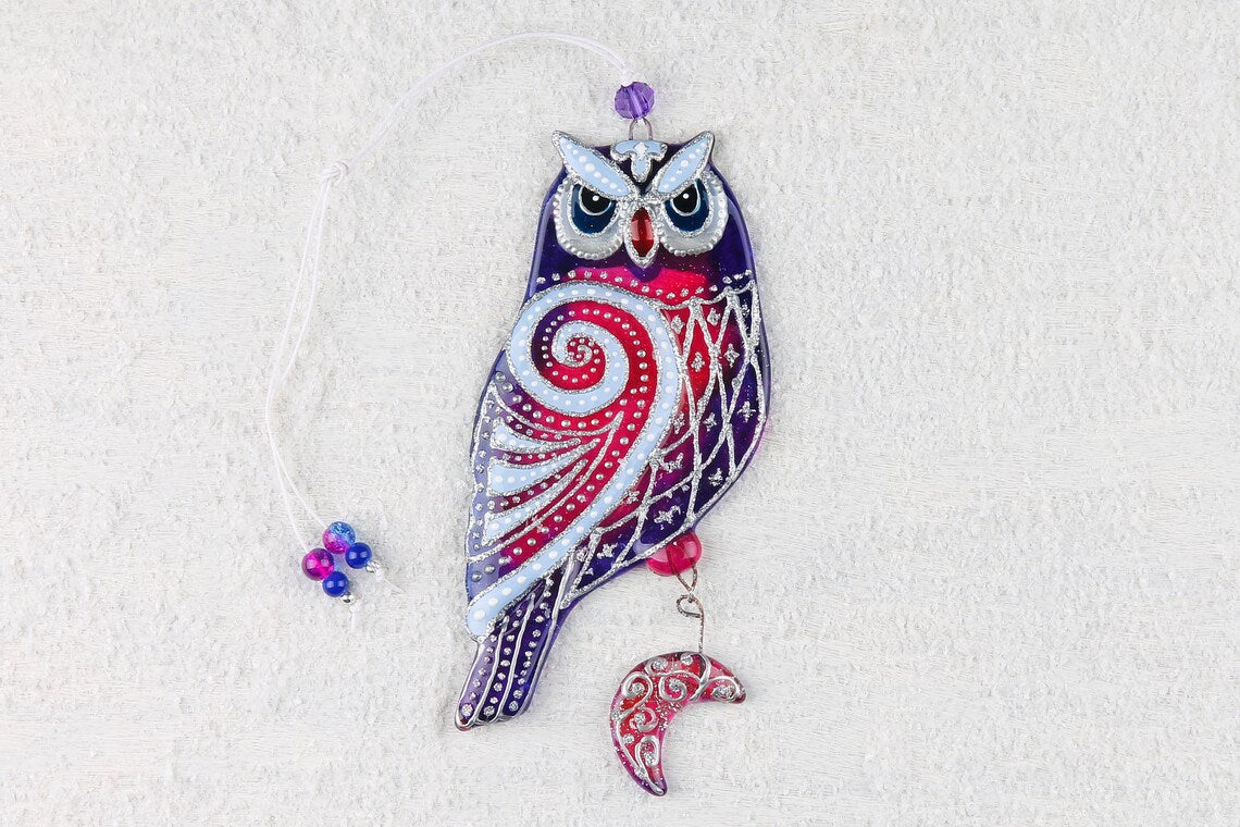 Hand-painted glass artwork of wise owls with sun and moon symbols, blue and red